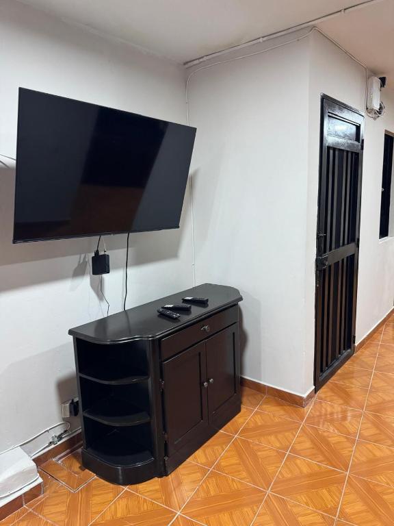 a living room with a flat screen tv on a wall at Casa del parque in Bello