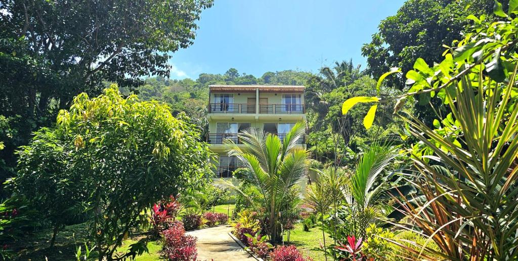 a building in the middle of a garden with trees at Casa Li Tayrona in El Zaino