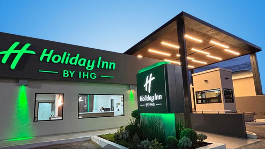 a holiday inn by hilton sign in front of a building at Holiday Inn & Suites Chihuahua Expo by IHG in Chihuahua