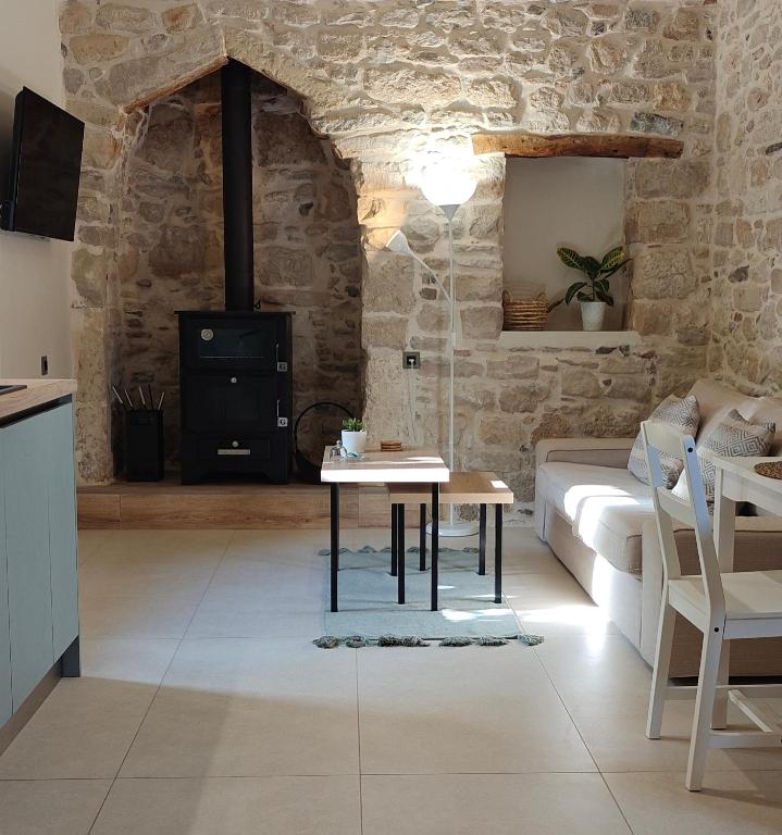 a living room with a table and a stove at Ellotis Stone Retreat in Áyioi Dhéka