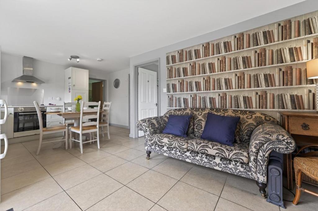 a living room with a couch and a wall of books at 2 Bed in Alkham oc-p34785 in Swingfield