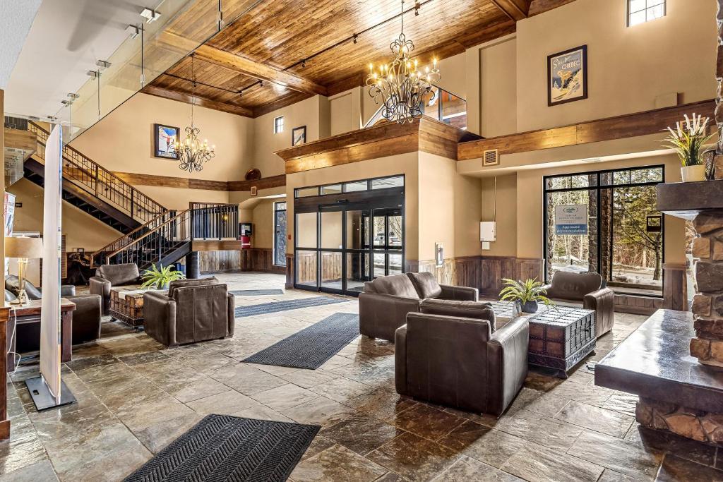 a large lobby with leather furniture and a staircase at Glacier & Mountaineer Lodge in Golden