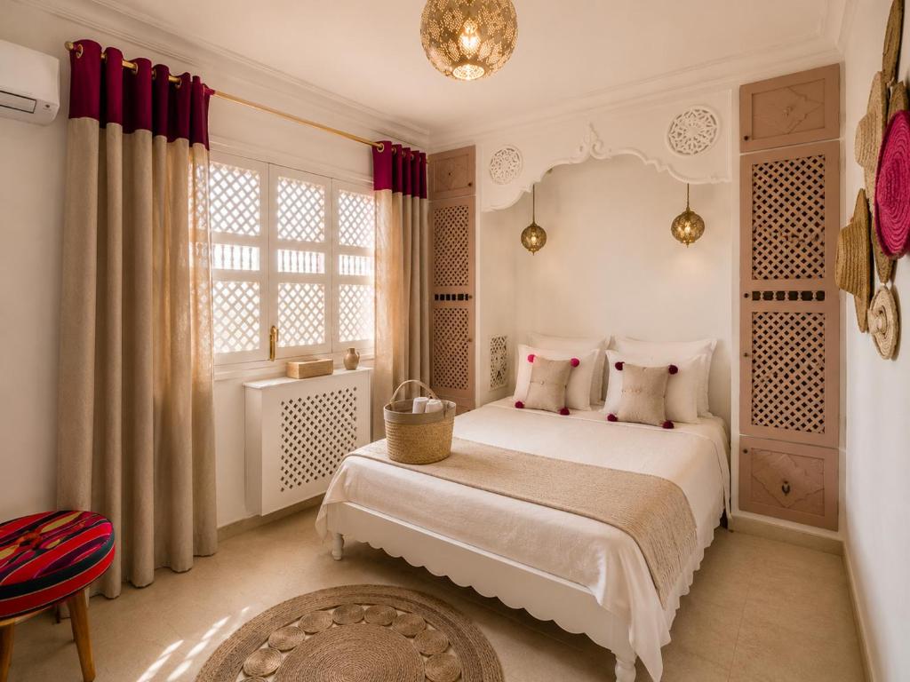 a bedroom with a white bed and a window at DAR COLIBRI - Maison de charme à Kélibia in Kelibia
