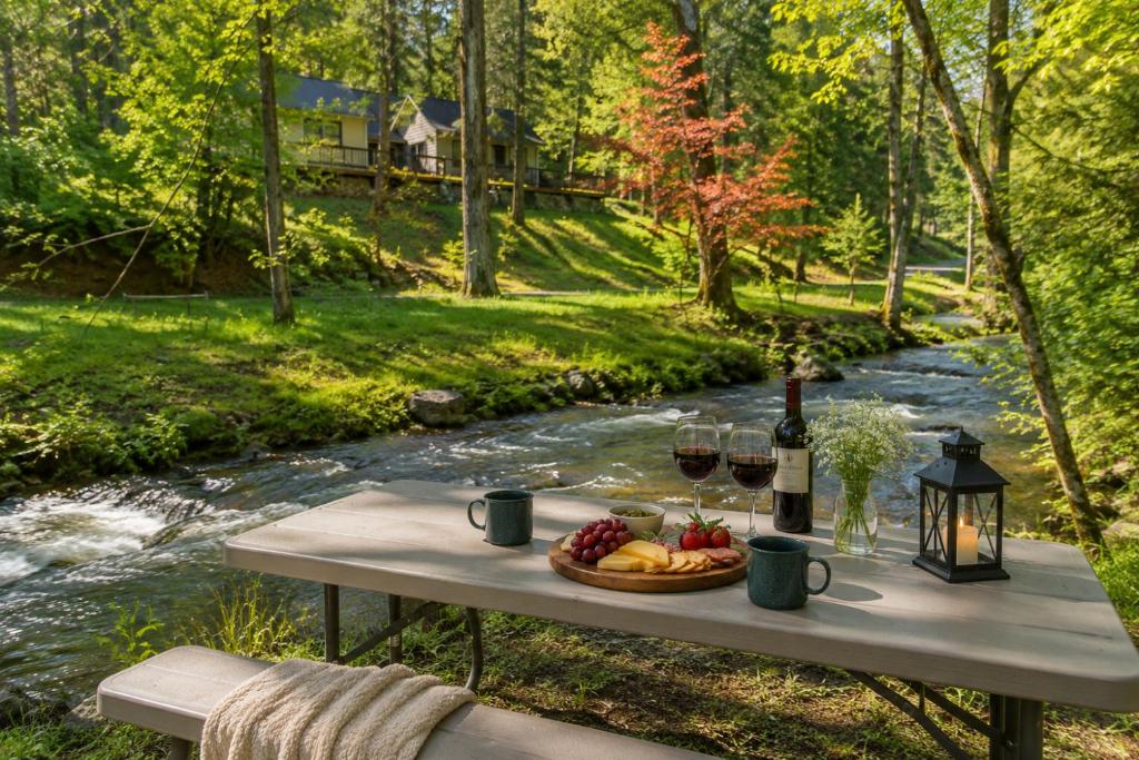 a picnic table with a basket of fruit and wine glasses at Secluded River Cabin Near Sly Park & Apple Hill in Placerville