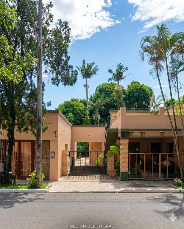 a house with palm trees in front of it at Amoite hotel boutique in Nuestra Señora del Rosario de Caa Catí