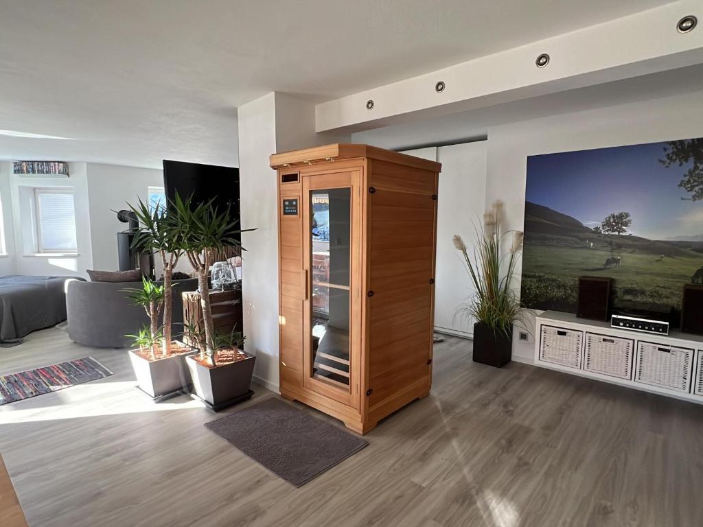 ein Wohnzimmer mit Fernseher und Holzschrank in der Unterkunft Franziska in Schwoich
