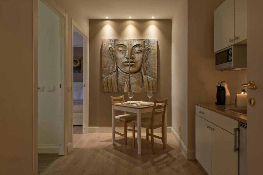 a kitchen with a table and a picture of a head at Aruna Suites in Rome