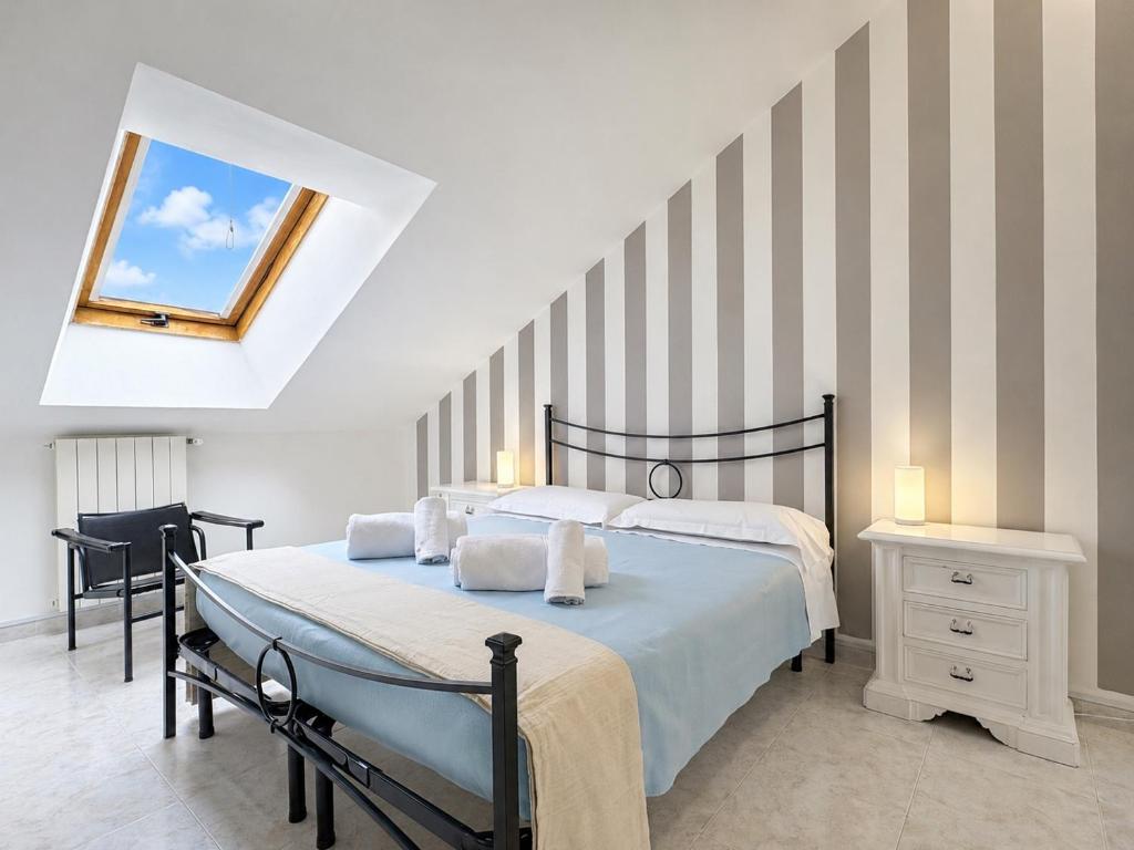 a bedroom with a large bed and a skylight at Cà di Lilly - Attic Suite AC Wi-Fi in Vado Ligure