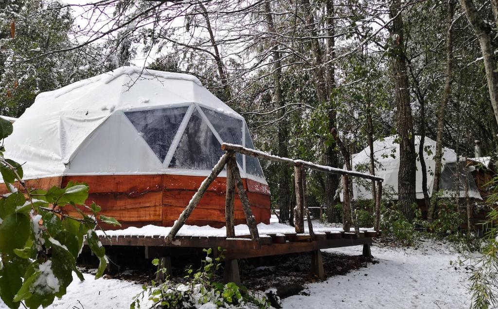 a yurt is sitting on a wooden platform in the snow at Centro Turistico Vortice Chile in Manzanar
