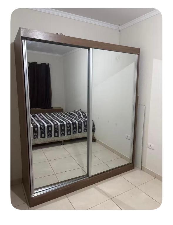 a mirror in a room with a bed in it at Raquel in Londrina