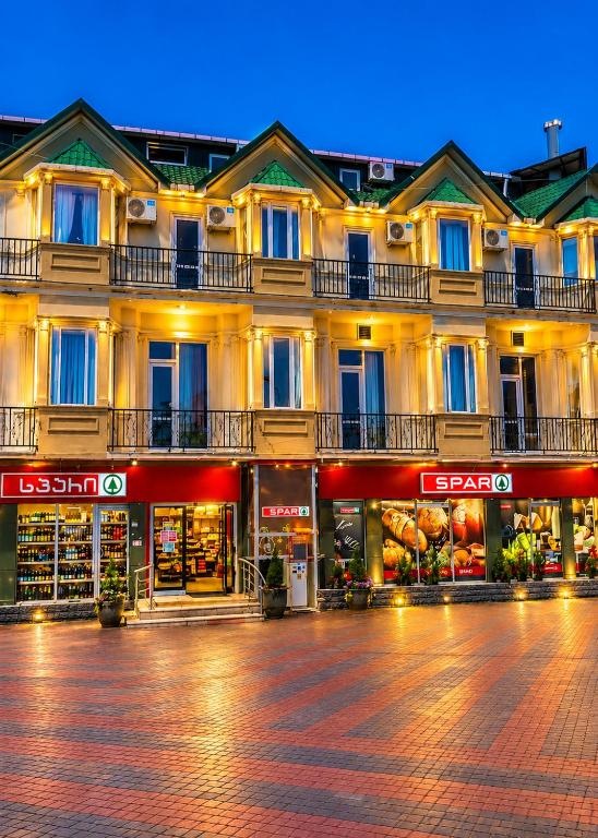 a building with stores in front of a street at Emilia Hotel Batumi Old Town in Batumi