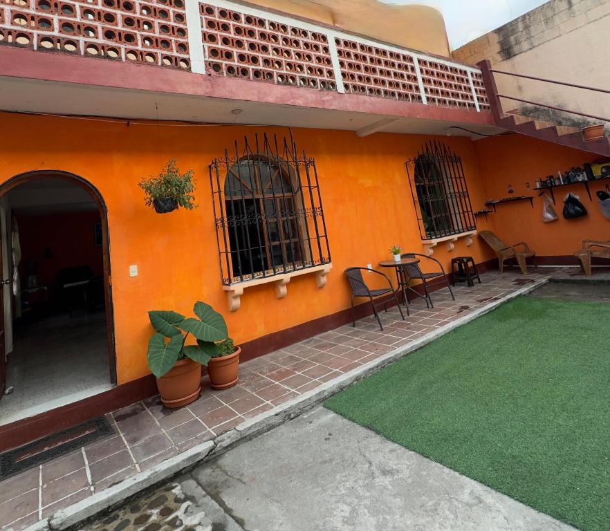an orange building with a table and chairs and a patio at Casa Nimacachi in Panajachel