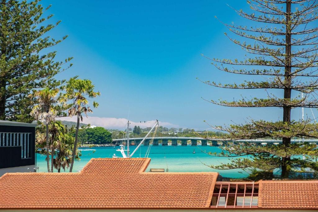 a view of a marina with a boat in the water at Beach Street Oasis - Tuncurry in Tuncurry
