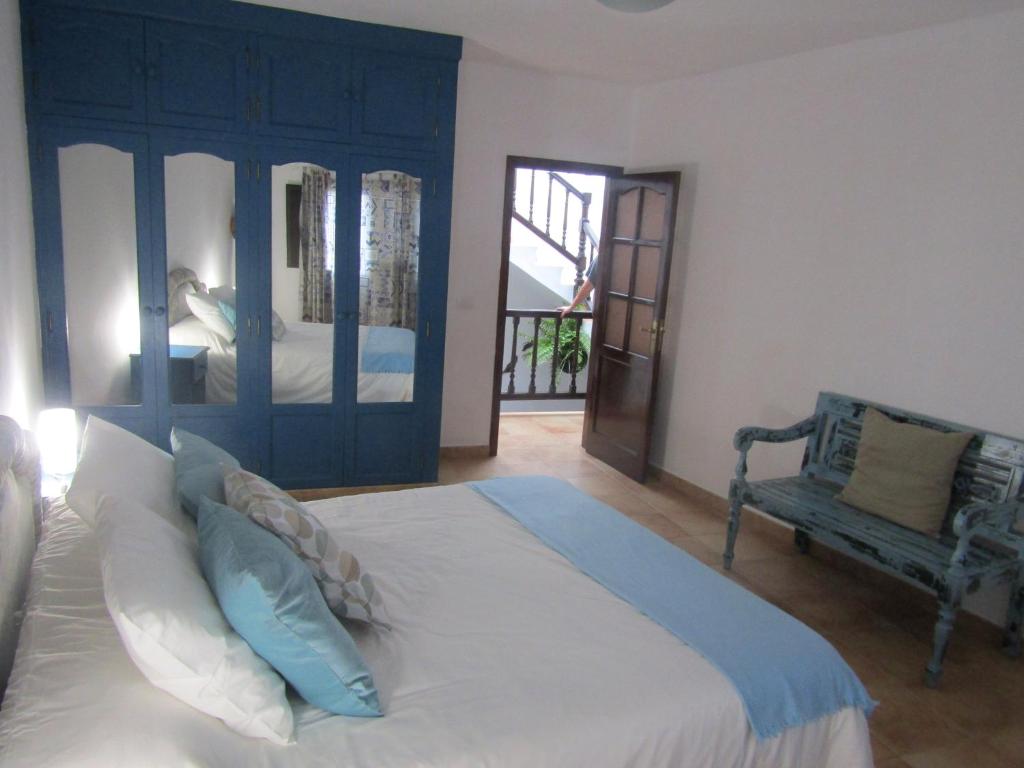 Un dormitorio con una cama grande y un banco. en La Casita Villalba, en Arrieta