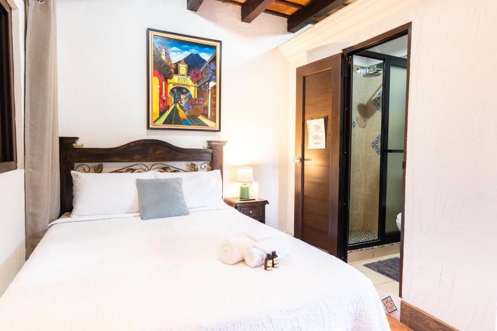 a bedroom with a large white bed with towels on it at Los Faroles Hotel & Spa in Antigua Guatemala