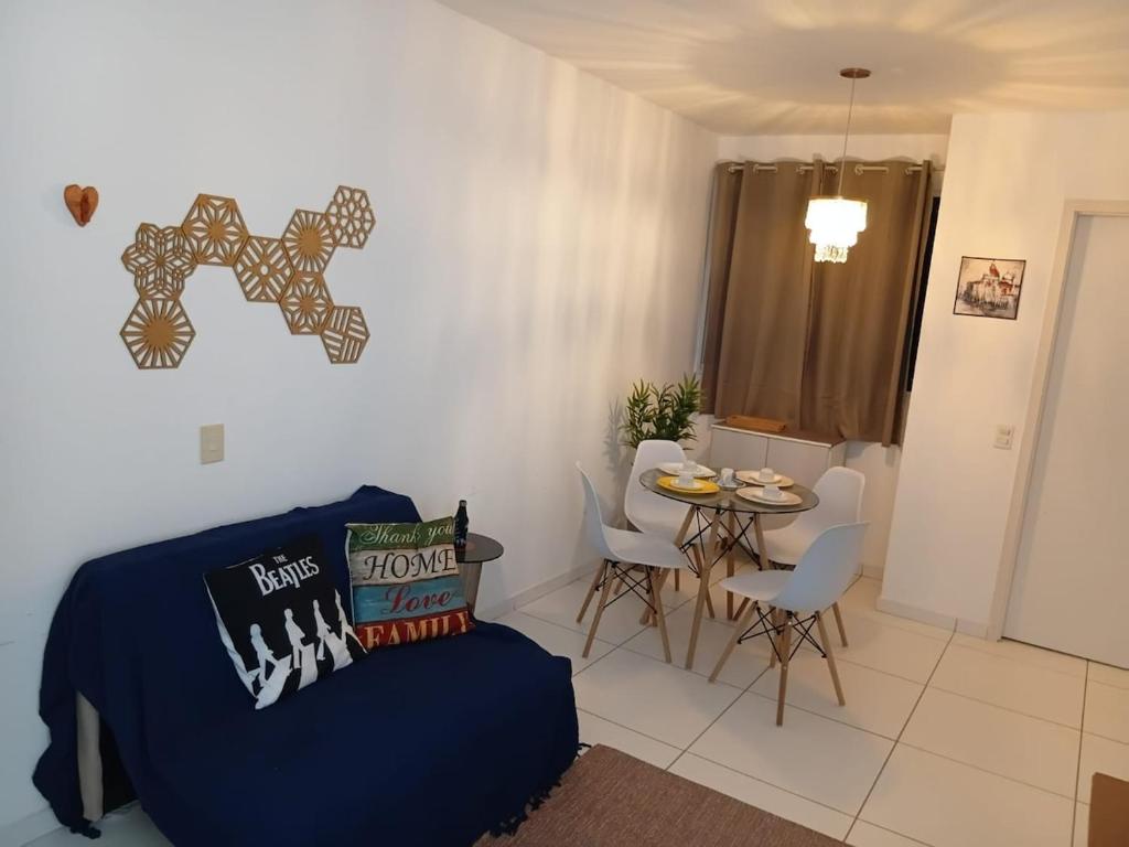 a living room with a blue couch and a table at Apto aconchegante próximo à UFS in São Cristóvão