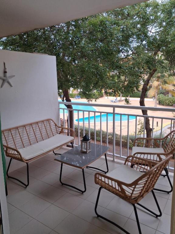 a patio with two chairs and a table on a balcony at Vila Verde Sal Calistemon in Prainha