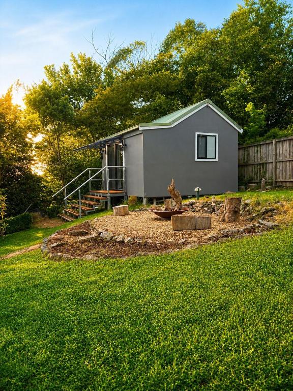 a backyard with a tiny house in the background at Cosy Studio- Blue Mountains in Wentworth Falls