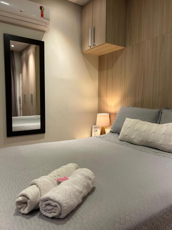 a bedroom with a bed with towels on it at Loft Studio bem localizado e novinho in Passo Fundo