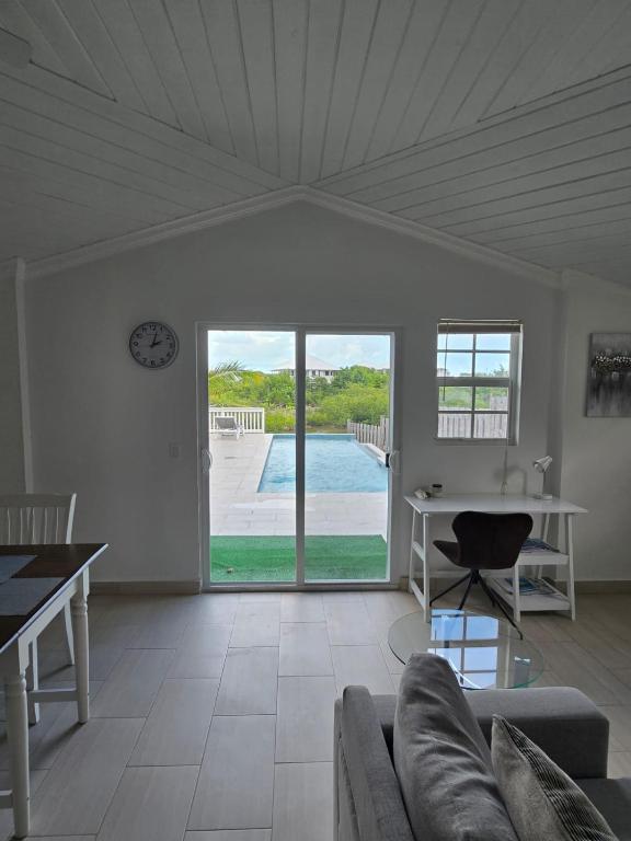 a living room with a couch and a table and a pool at Swan Cottages #5 Waterfront in Providenciales