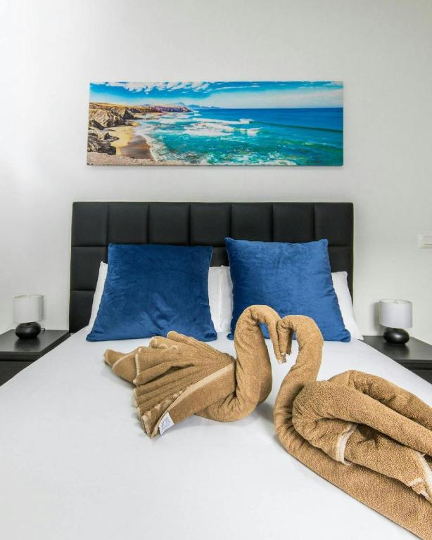 a bed with two towel swans laying on it at Apartamento Atenea in San Bartolomé