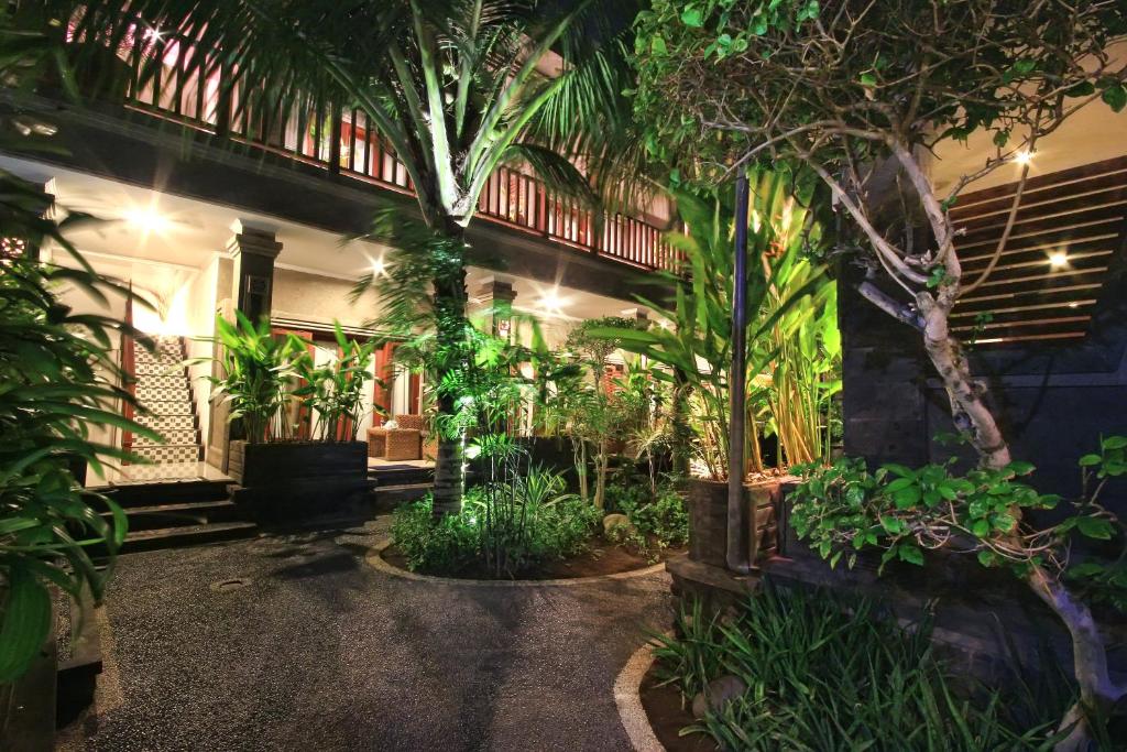 a courtyard of a house with trees and plants at Letos Kubu 1 in Kuta