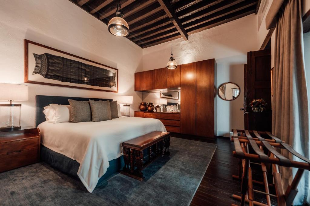 ein Schlafzimmer mit einem großen Bett und einem Stuhl in der Unterkunft Antiguo Molino de San Jerónimo in Mexiko-Stadt