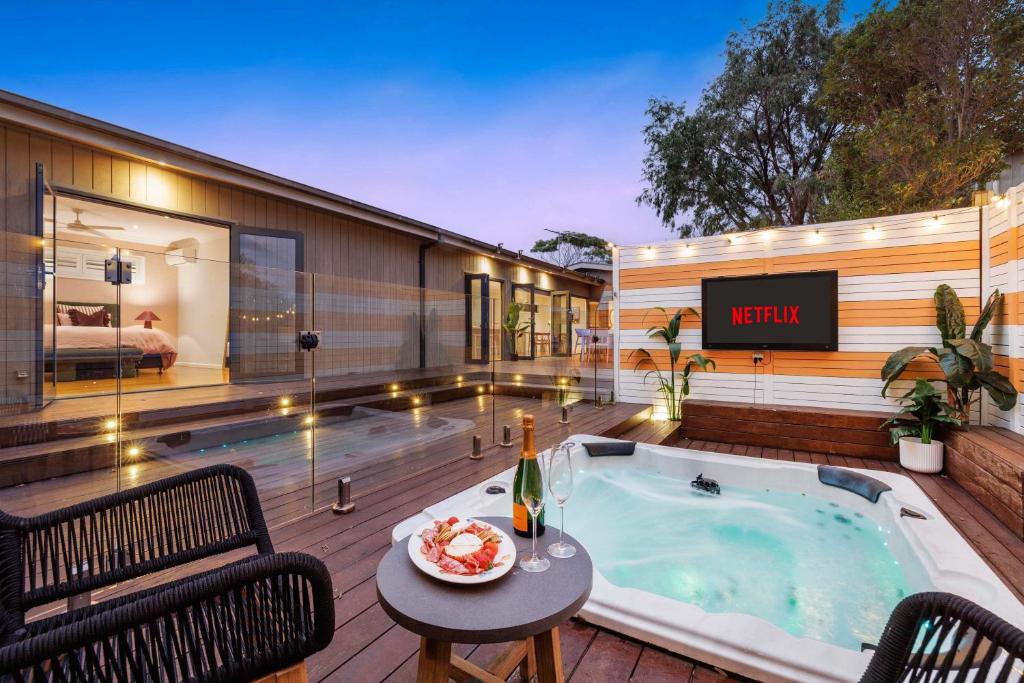 a hot tub on a deck next to a building at Zen Haven with Sauna & Spa in Tootgarook