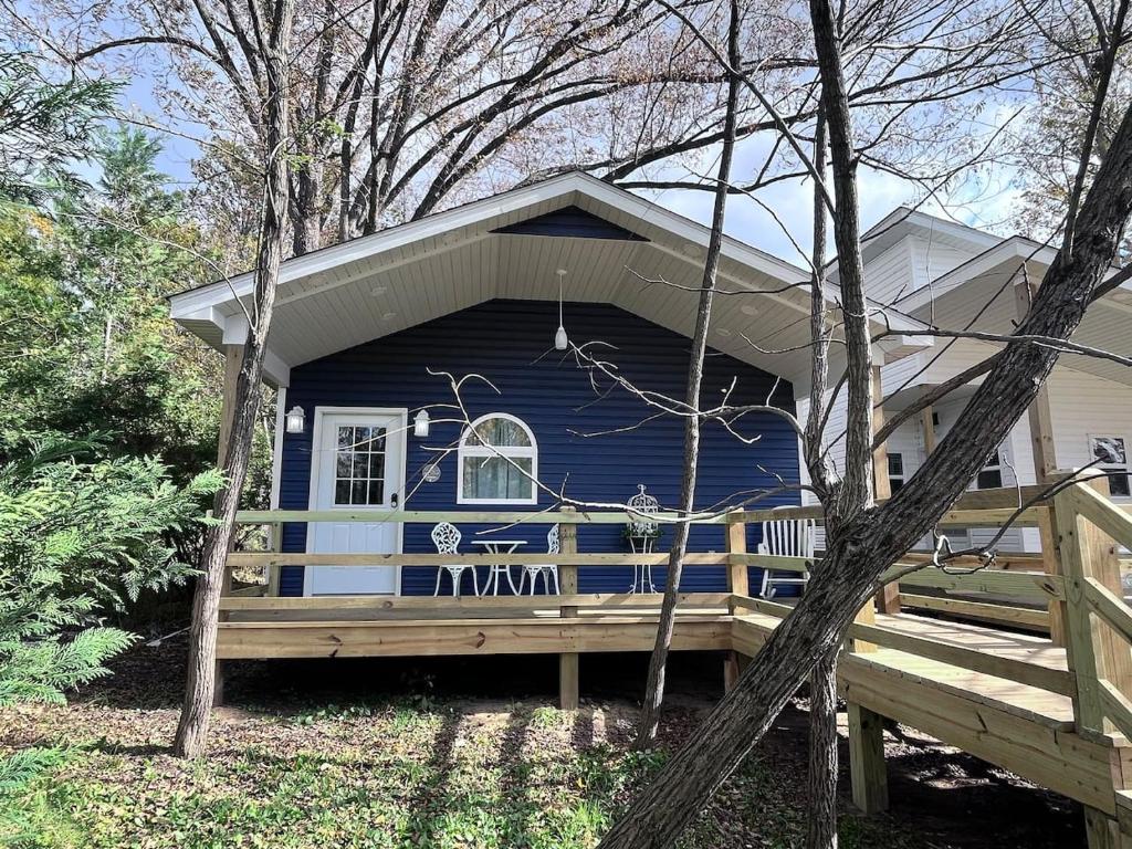 a blue tiny house with a porch at Romantic Tea Cottage with Deck and Nature in Cape Girardeau