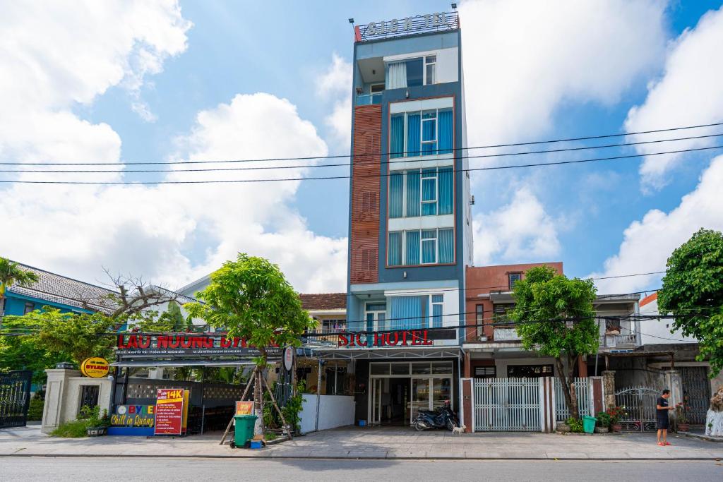 a tall building on the corner of a street at Khách sạn SIC Quảng Bình in Dong Hoi
