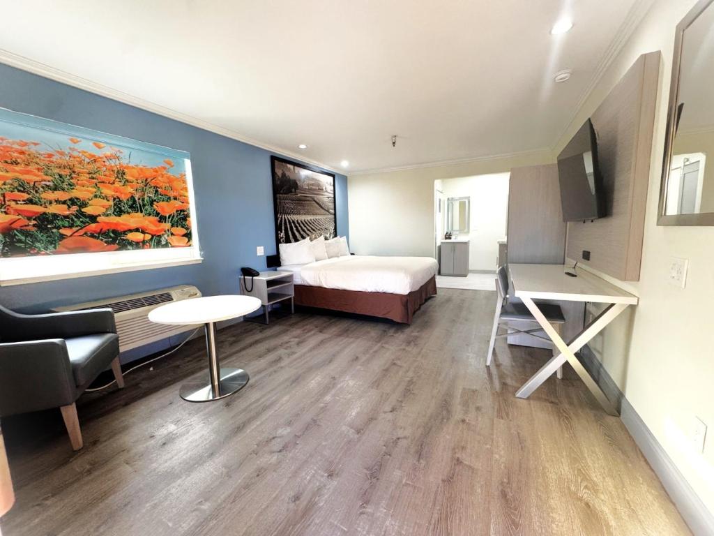 a hotel room with a bed and a large painting on the wall at INN at King City in King City