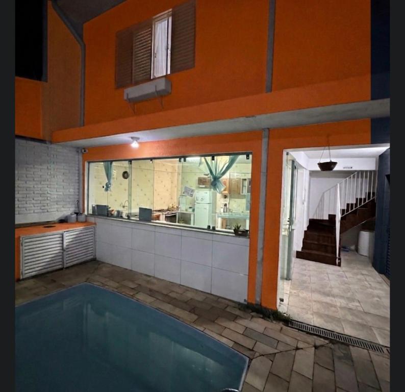 a swimming pool in the middle of a house at Pousada Peruibe Praia Centro in Peruíbe