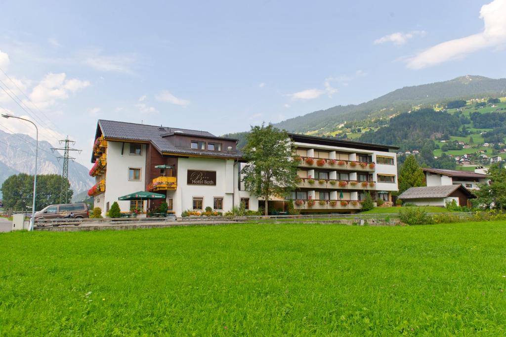 ein Hotel mit einem grünen Feld davor in der Unterkunft Hotel Both in Schruns-Tschagguns