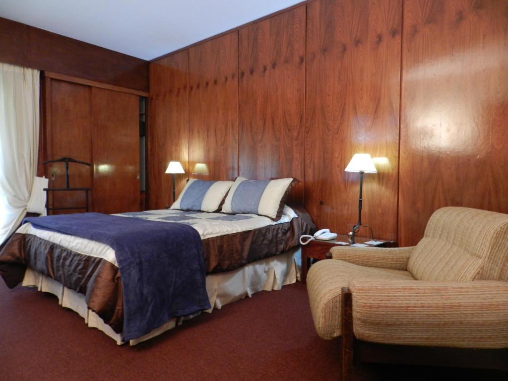 a hotel room with a bed and a chair at Hotel Ayuí Resort & spa Termal in Concordia