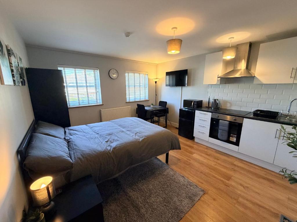 a small bedroom with a bed and a kitchen at Leatherhead Studios by WorkStay in Leatherhead
