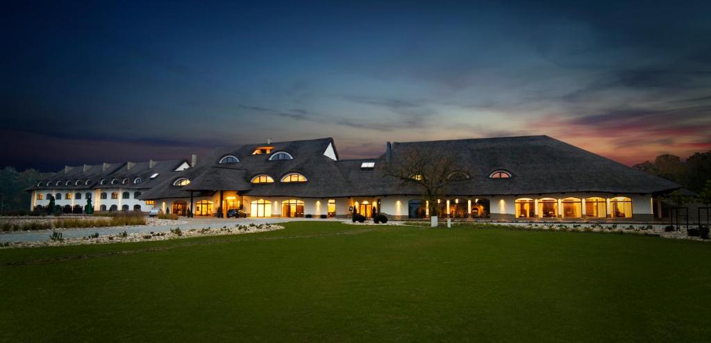 a large house with a gambrel roof at night at Hotel Remes in Opalenica