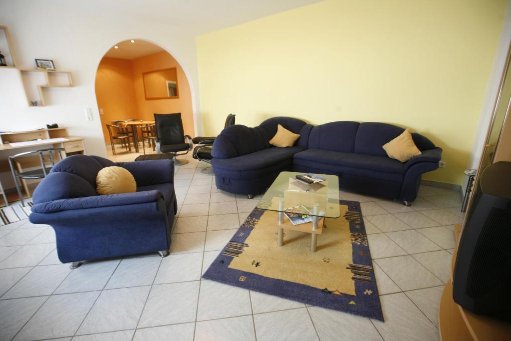 a living room with two blue couches and a table at Ferienwohnung Pretz in Braubach
