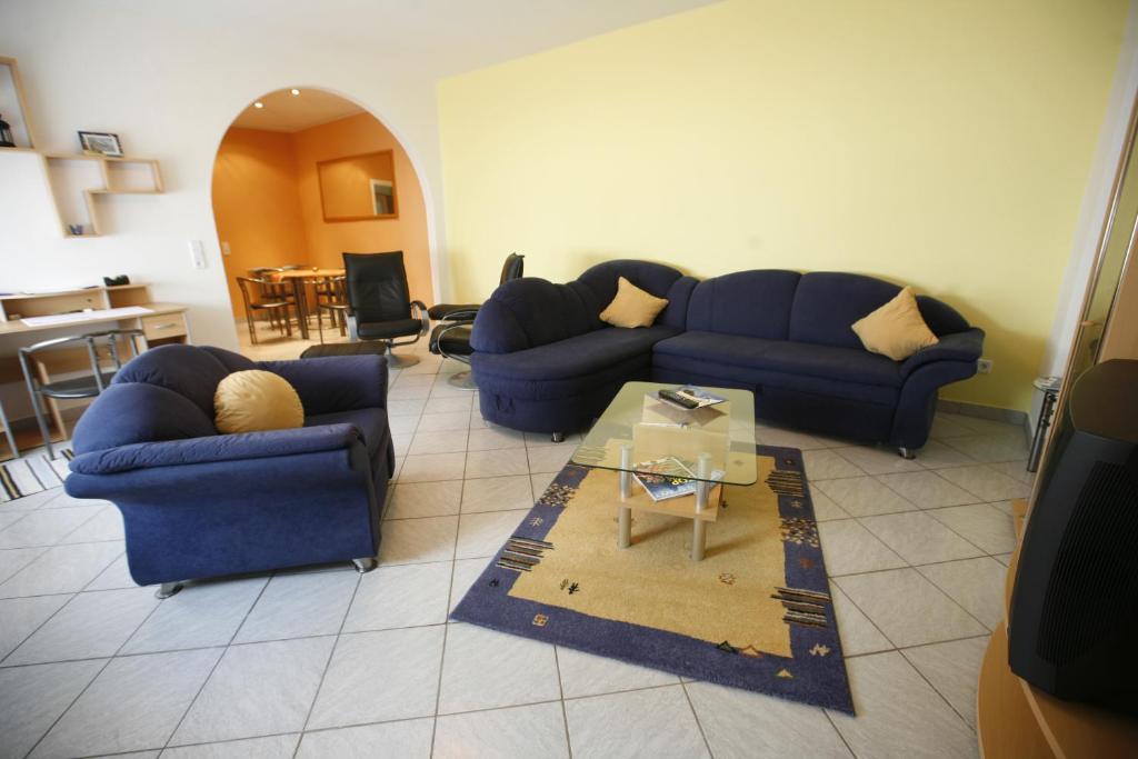 ein Wohnzimmer mit zwei blauen Sofas und einem Tisch in der Unterkunft Ferienwohnung Pretz in Braubach