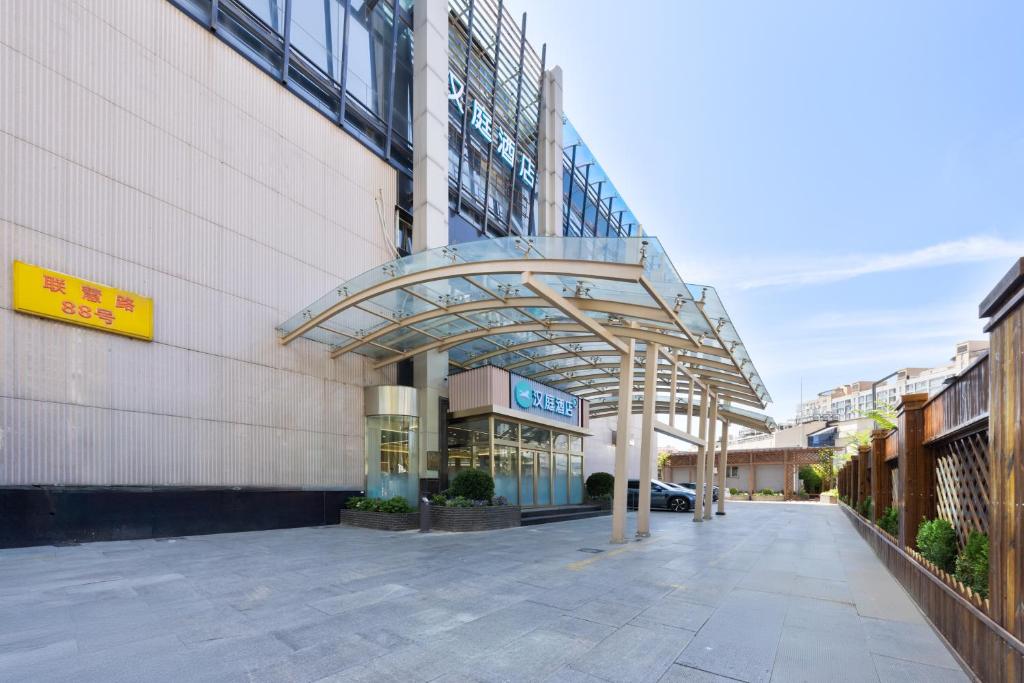 an entrance to a building with a glass canopy at Hanting Hotel Beijing Xizhimen in Beijing