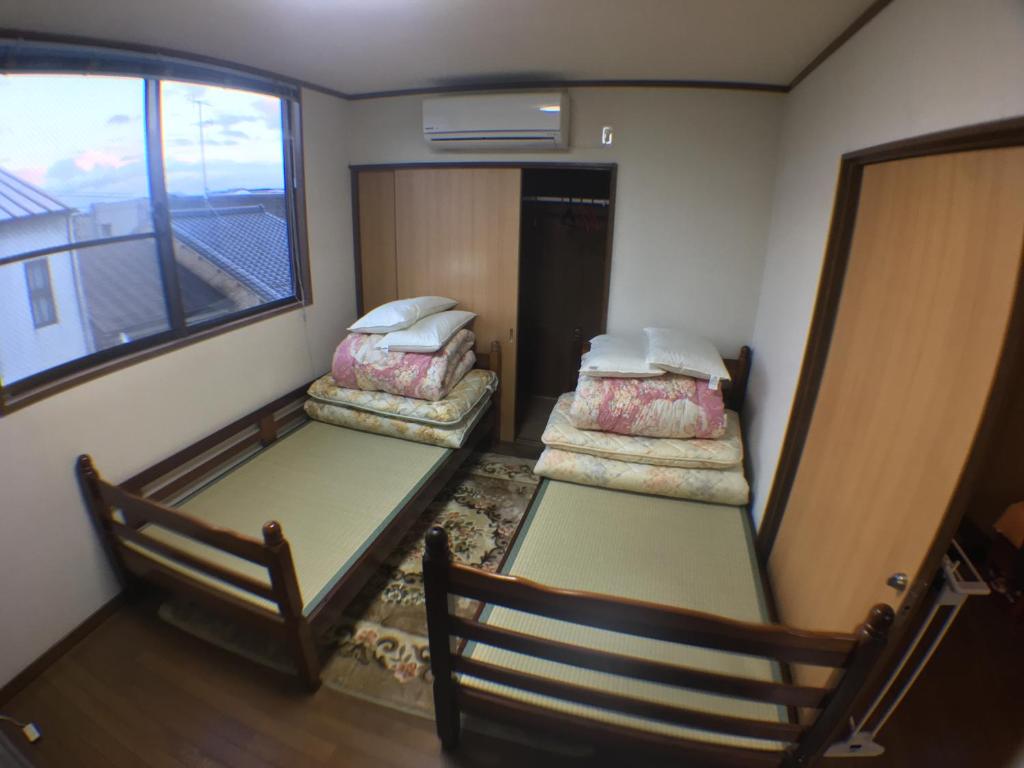 2 łóżka piętrowe w pokoju z oknem w obiekcie Arashiyama Bamboo Guest House w mieście Kioto