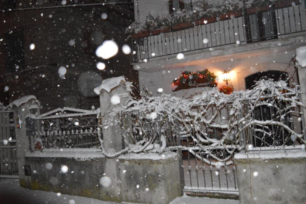 un cortile coperto di neve con un battesimo su un edificio di Dulcamara a Pescasseroli