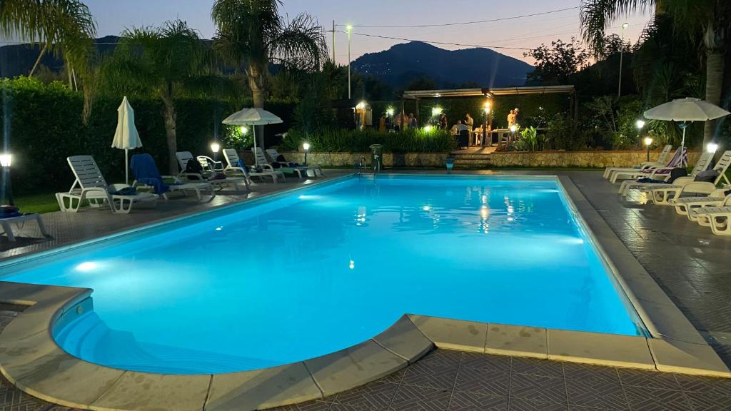 a large blue swimming pool at night at Sole nascente in Furci Siculo