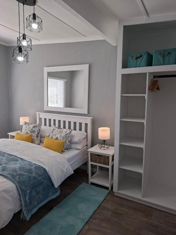 a bedroom with a bed and a book shelf at 7onthebeach unit 3 in Jeffreys Bay