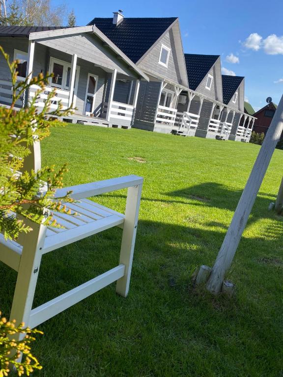 a white bench in front of a house at Przystanek Wyspa in Gdańsk