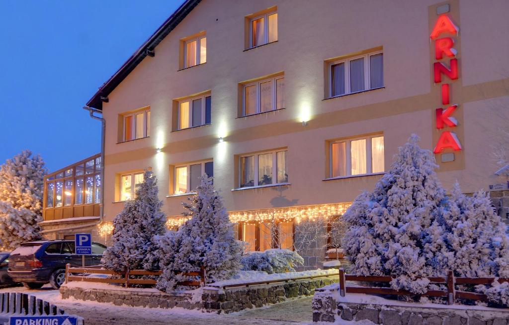 a hotel with christmas trees in front of it at Willa Arnika in Karpacz
