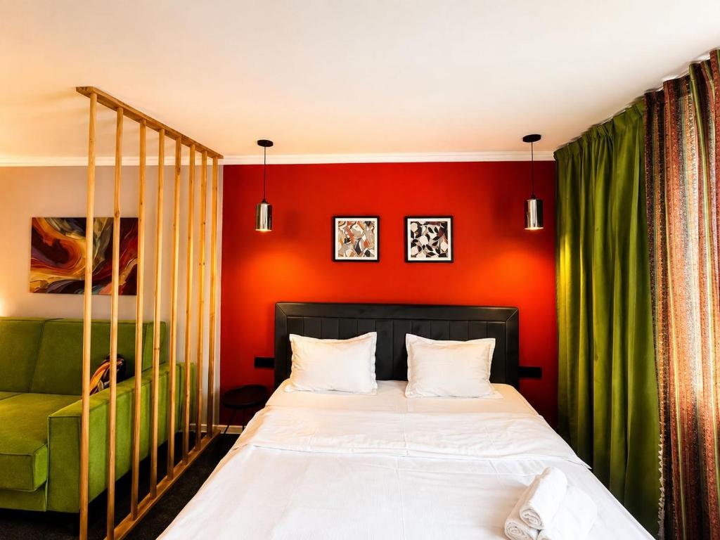 a bedroom with a bed and a green couch at APART-HOTEl 95 in Almaty