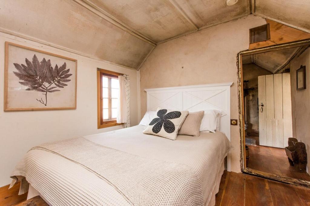 a bedroom with a white bed and a mirror at Mrs Banks in Robe