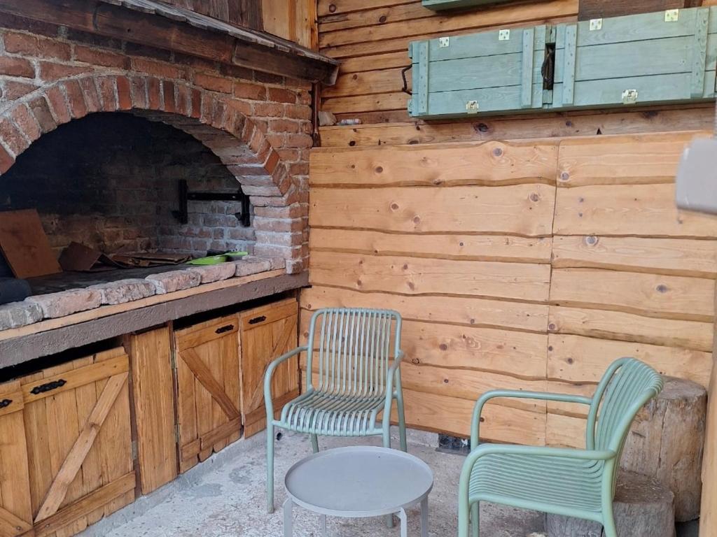 two chairs and a table in front of a fireplace at Kuca Kosta in Pale