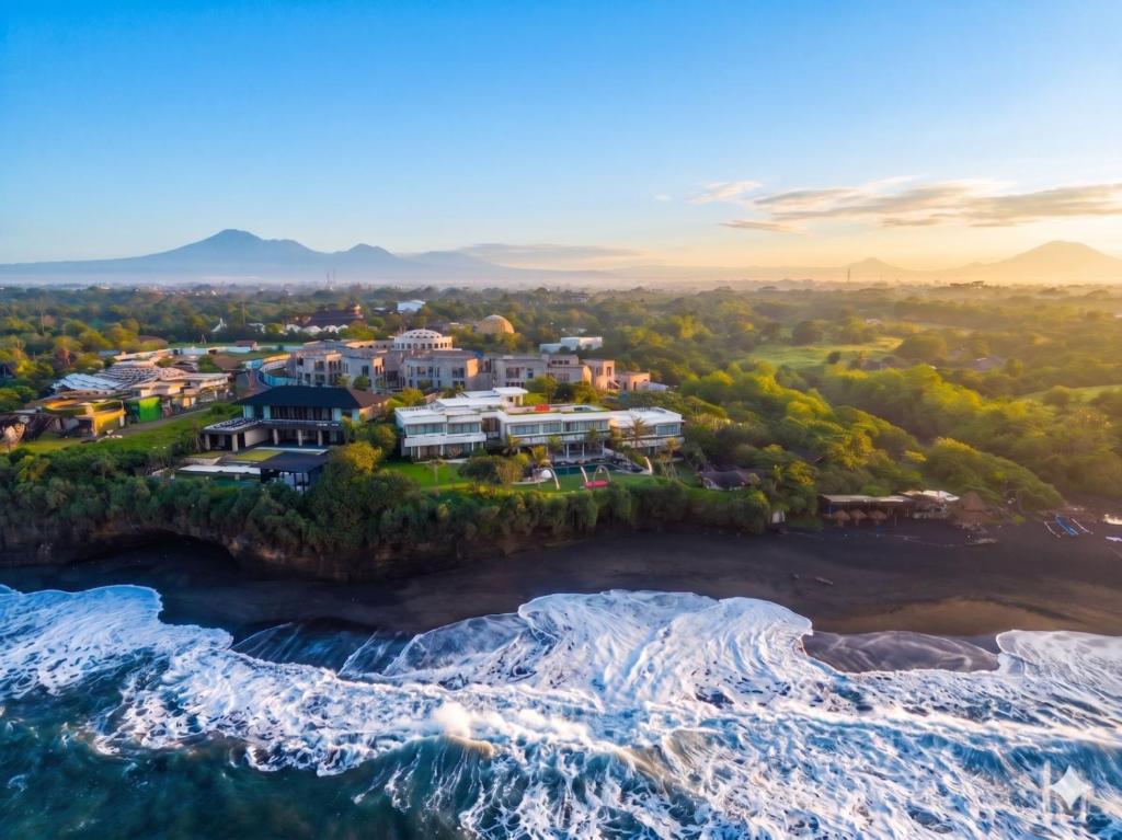 an aerial view of a resort on the shore of the ocean at Oshom Bali at Nuanu Creative City in Canggu