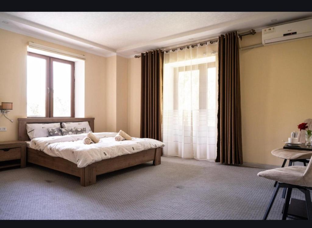 a bedroom with a bed and a large window at Tem Hotel in Khorog